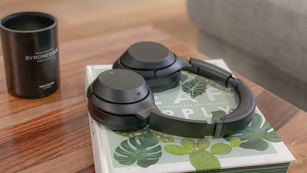 Sony WH-1000MX3 noise cancelling headphones on a book with a candle