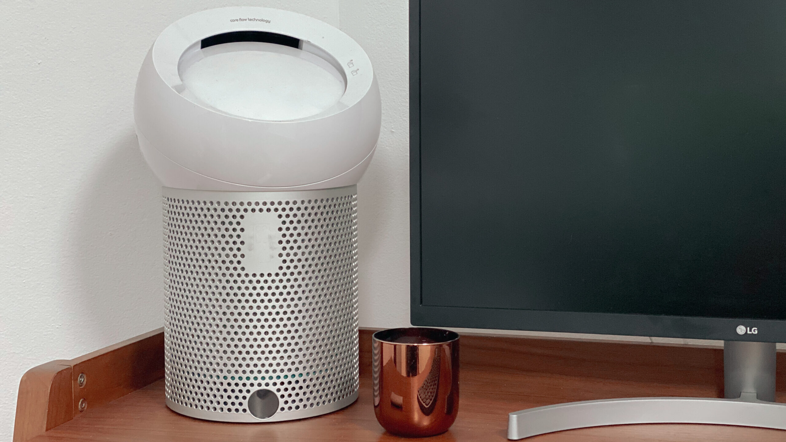 Dyson Cool Me personal purifying fan next to a candle and monitor