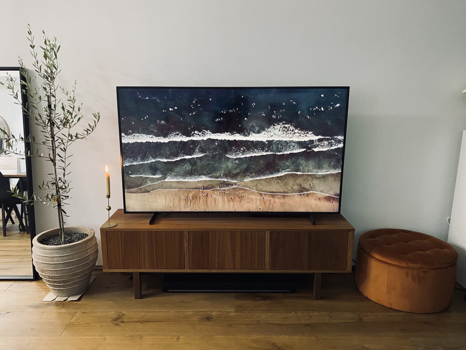 65-inch Samsung Frame TV 2021 model on a brown wood entertainment unit in Art Mode