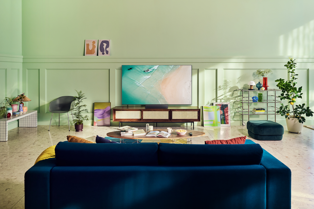 LG G2 Gallery OLED sitting on an entertainment unit in a mint green living room