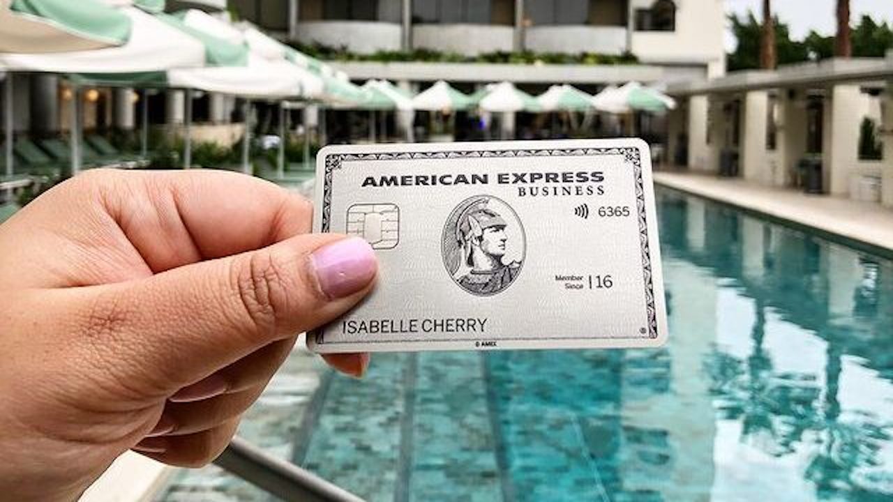 An American Express Platinum card in front of a pool at a luxury hotel